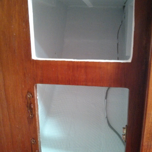 lower locker forward of starboard salon seat / berth with a fresh coat of white paint