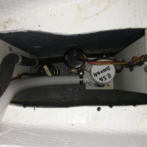 looking down into lower bilge with lower bilge pump float switch & hose on left and middle bilge pump & float switch on right