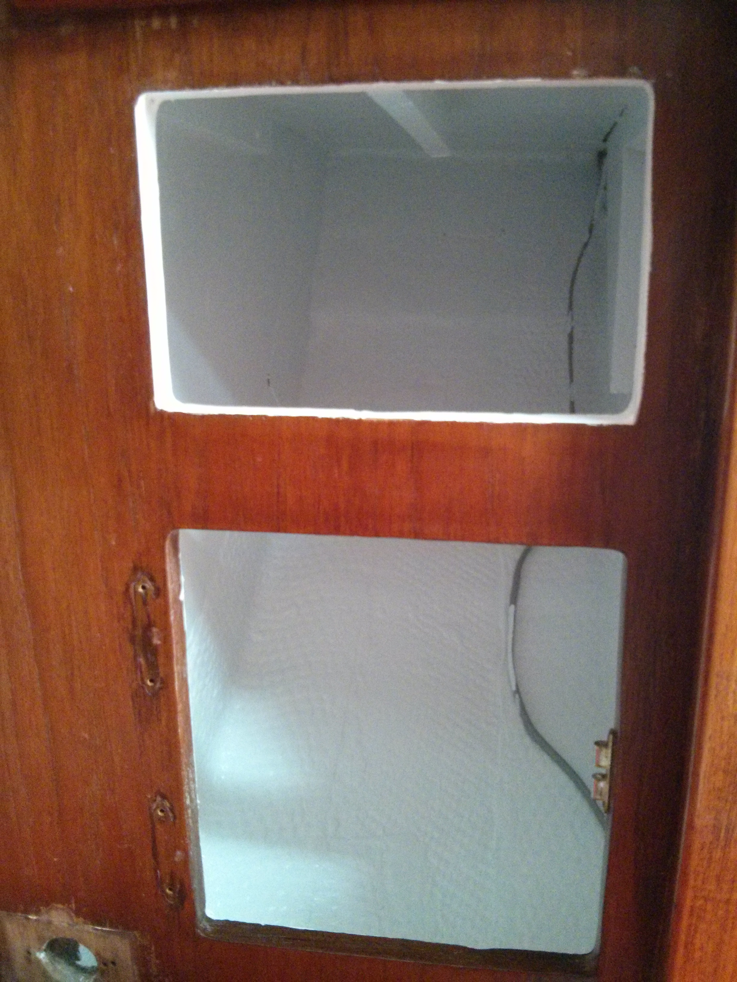 lower locker forward of starboard salon seat / berth with a fresh coat of white paint